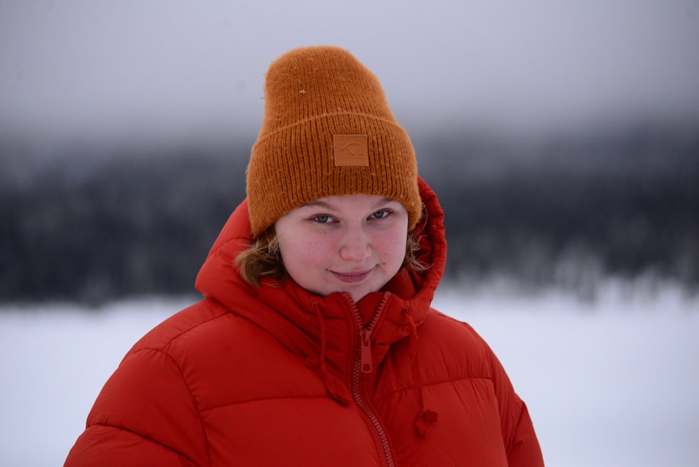 a woman in a red jacket and a brown hat