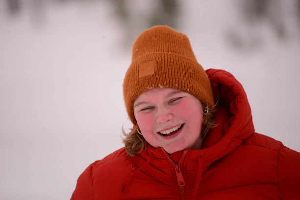 Smiling customer wearing a Minnesota Hodl hat outdoors on a snowy day.