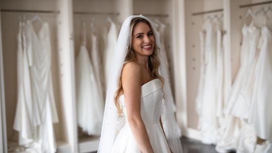 Bride trying on a beautiful wedding dress in a bright boutique.