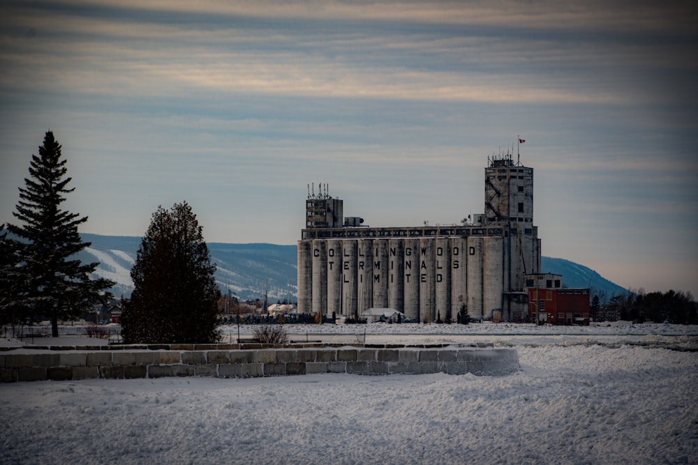 a large building with a clock tower in the middle of a snowy field