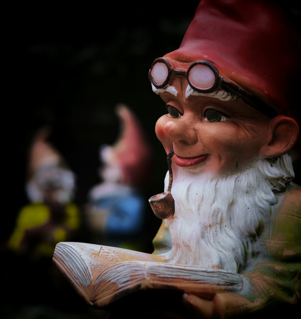 a statue of a gnome reading a book