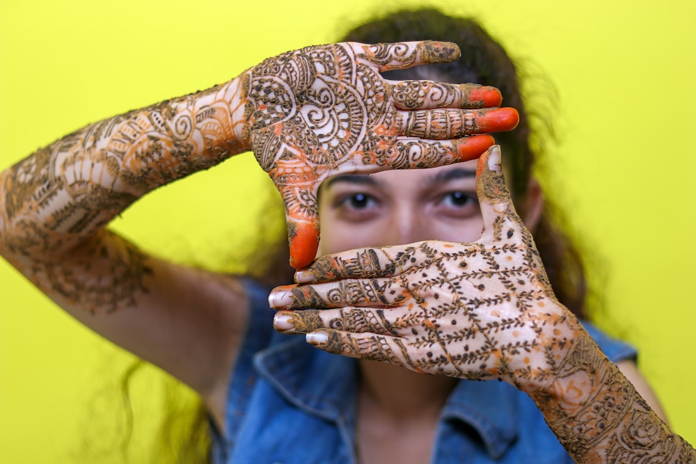 a woman holding her hands up to her face