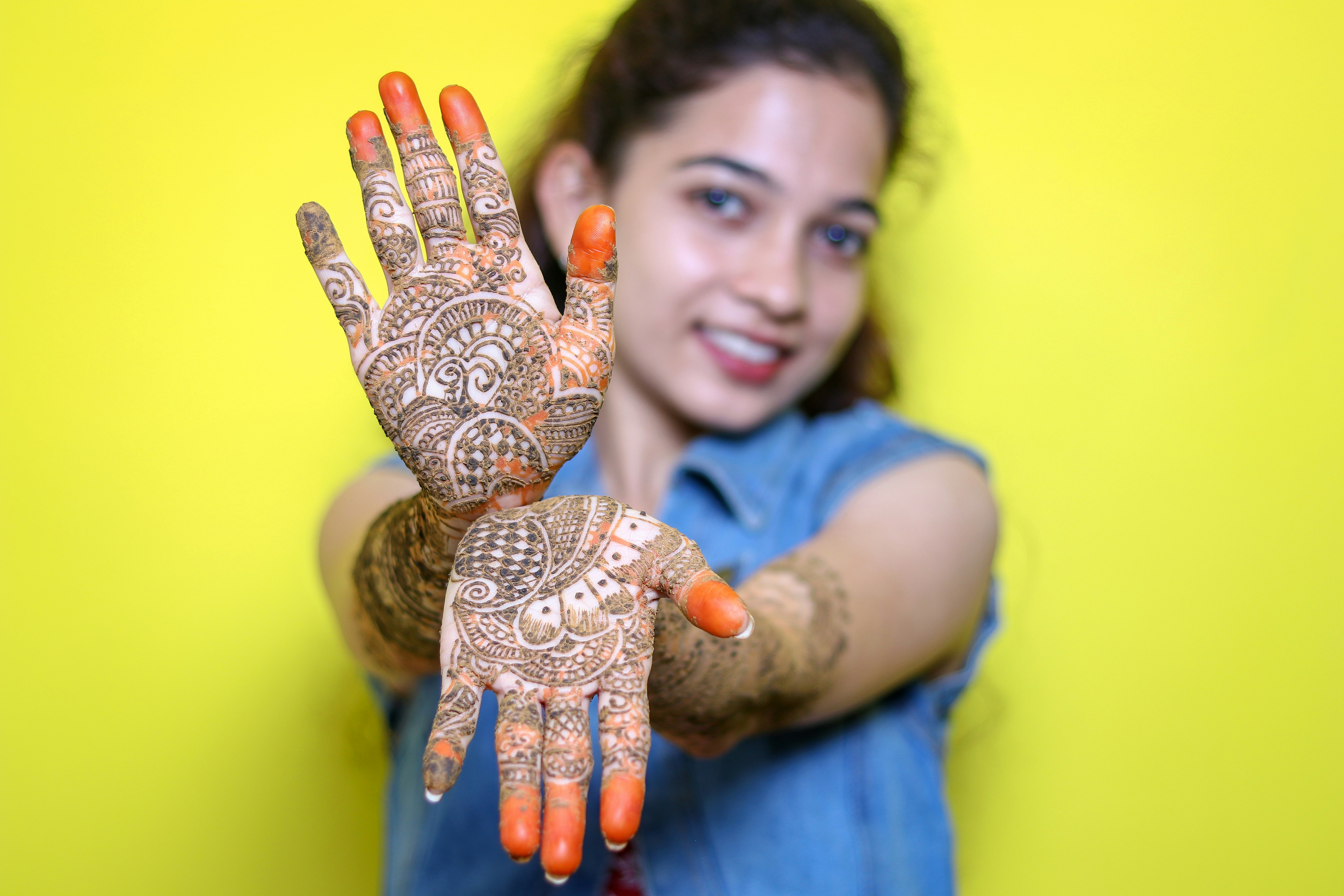 a woman holding up her hands with henna on it