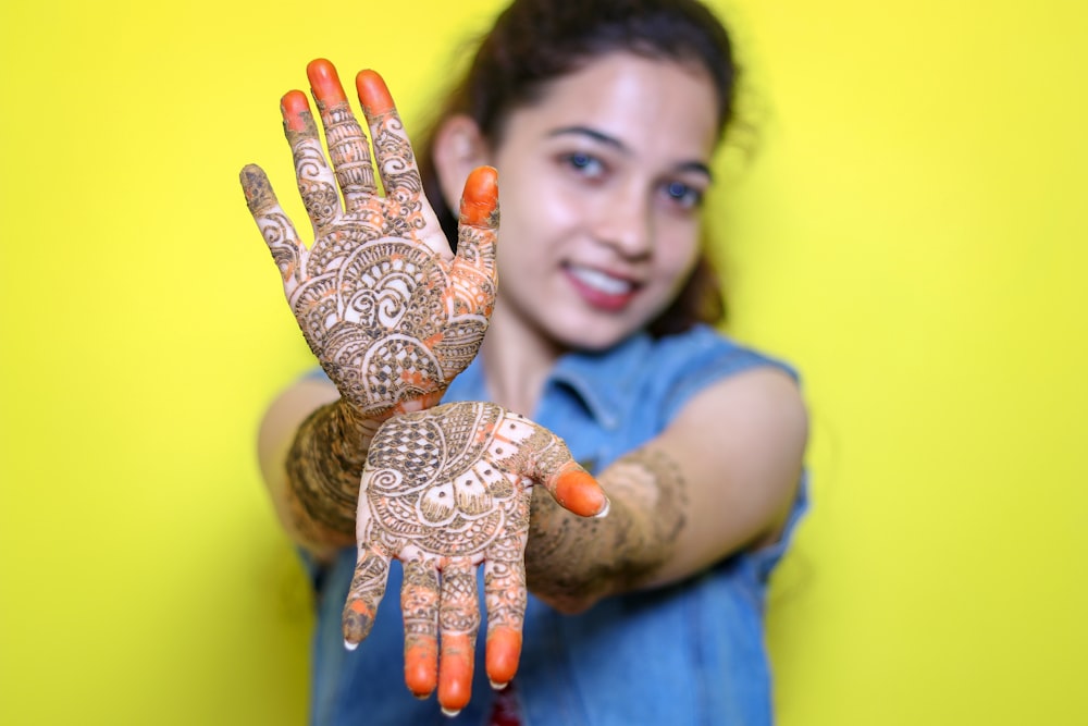 a woman holding up her hands with henna on it