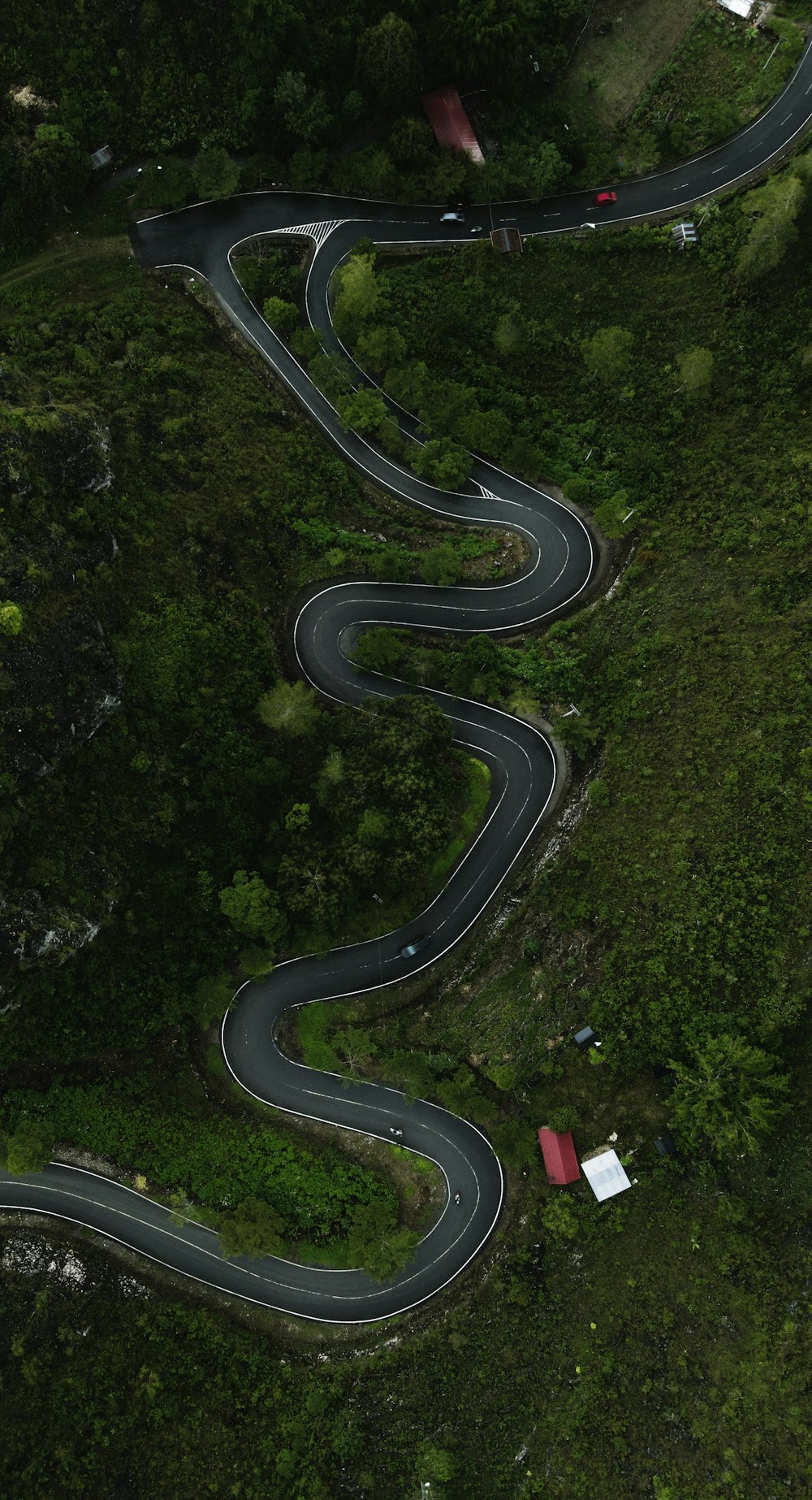 an aerial view of a winding road in the mountains