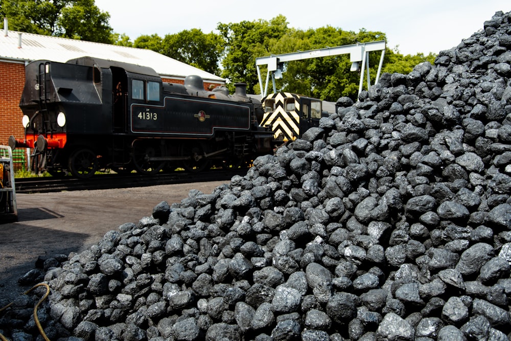 a train traveling past a pile of coal