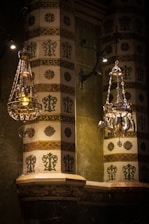 A beautifully adorned Sumatran pelaminan with deep gold and ivory accents under soft lighting.