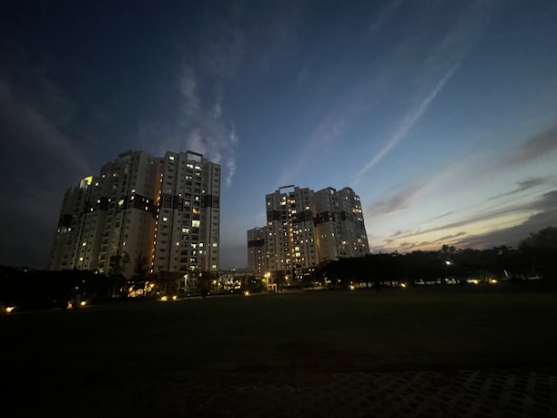 Elegant twilight view of Savyavasa’s sleek high-rise towers glowing against the night sky.