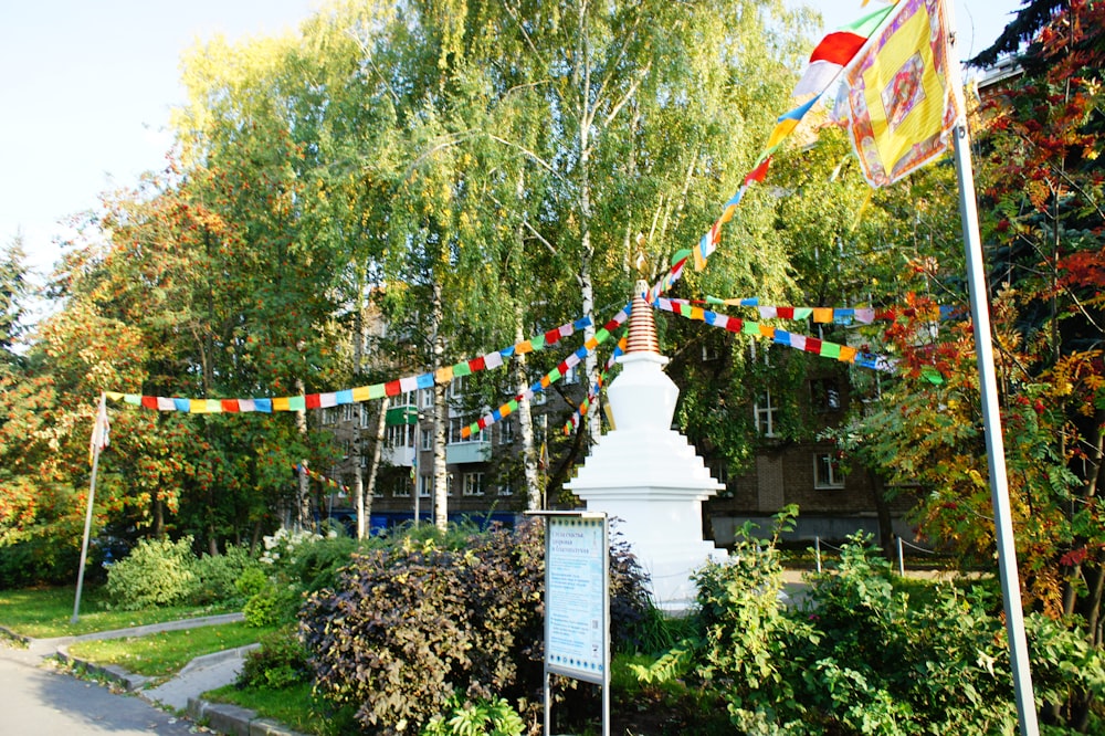 a white monument in the middle of a park