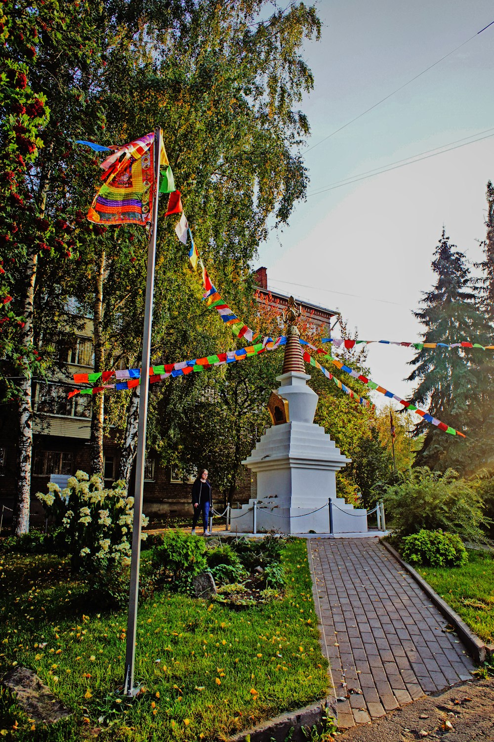 a small white monument in a park surrounded by trees