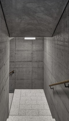 an empty room with concrete walls and stairs