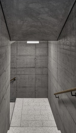 an empty room with concrete walls and stairs