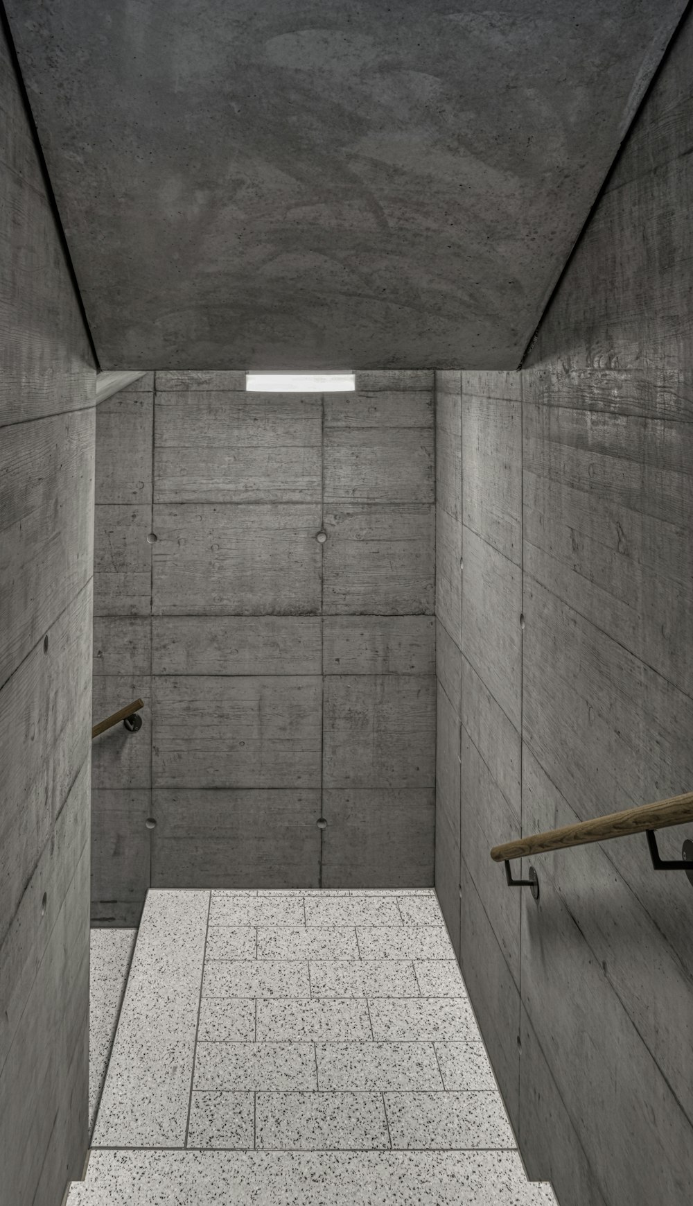 an empty room with concrete walls and stairs