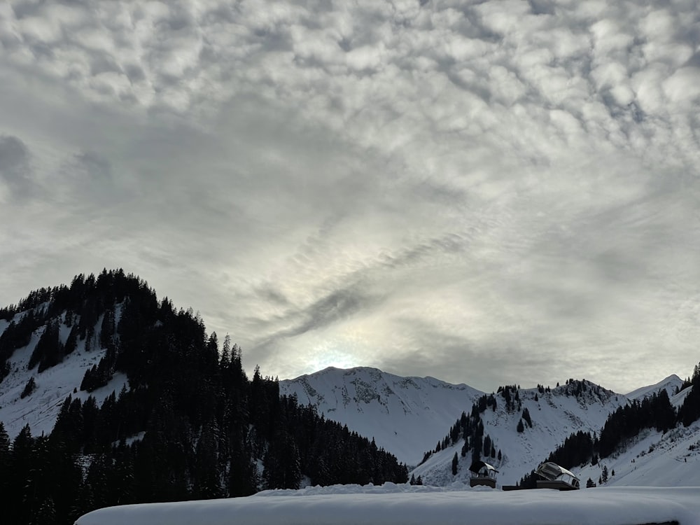 a mountain covered in snow under a cloudy sky