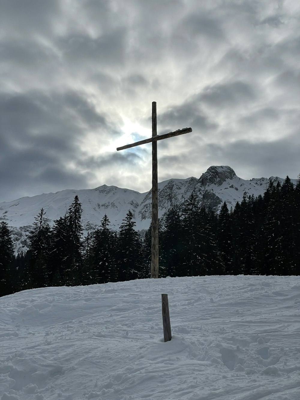 a cross on top of a snow covered hill