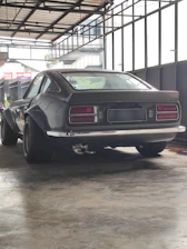 A sleek restored classic car parked in a luxurious Mallorca garage with gold accents.