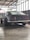 A classic car being showcased after restoration in a garage.