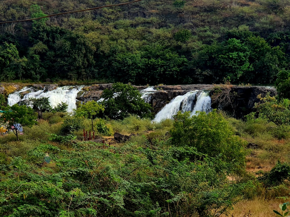 a group of people standing in front of a waterfall