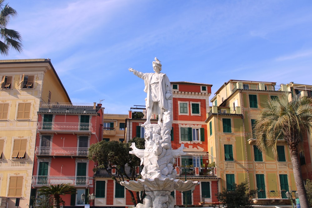 a statue of jesus in front of a multi - colored building