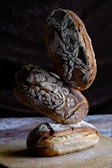 Artisan bread loaves stacked on a rustic wooden table.