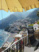 a balcony with a view of a town and the ocean
