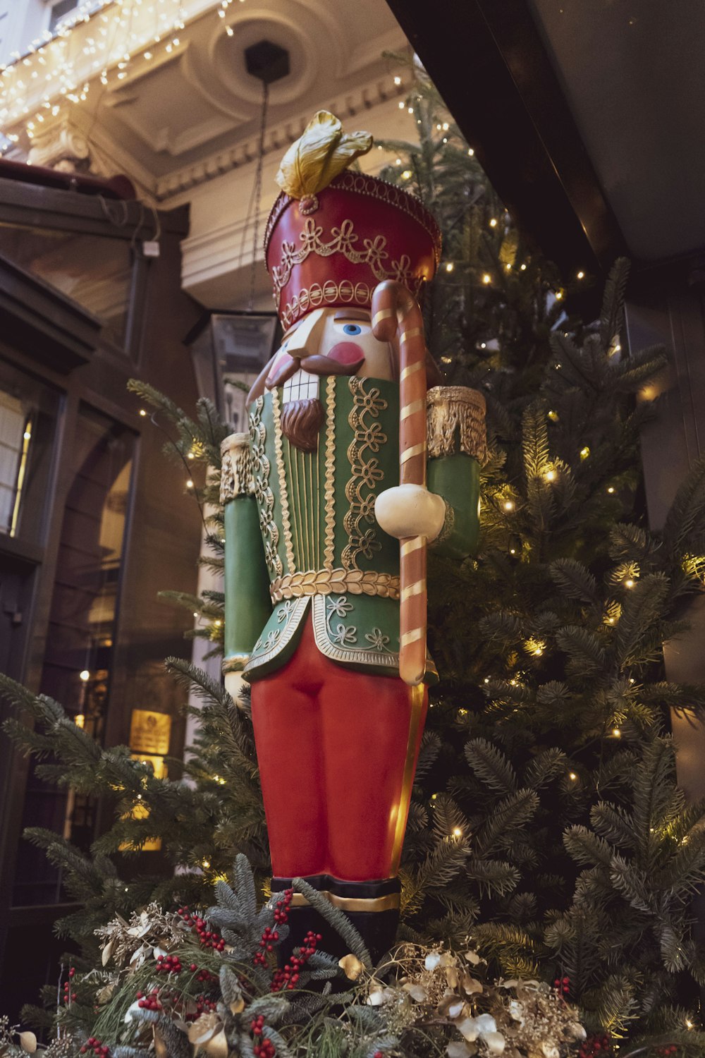 a large nutcracker statue in front of a christmas tree