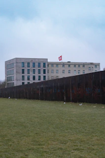 Wide shot of a nearly completed hospital exterior with Swiss and Peruvian flags visible