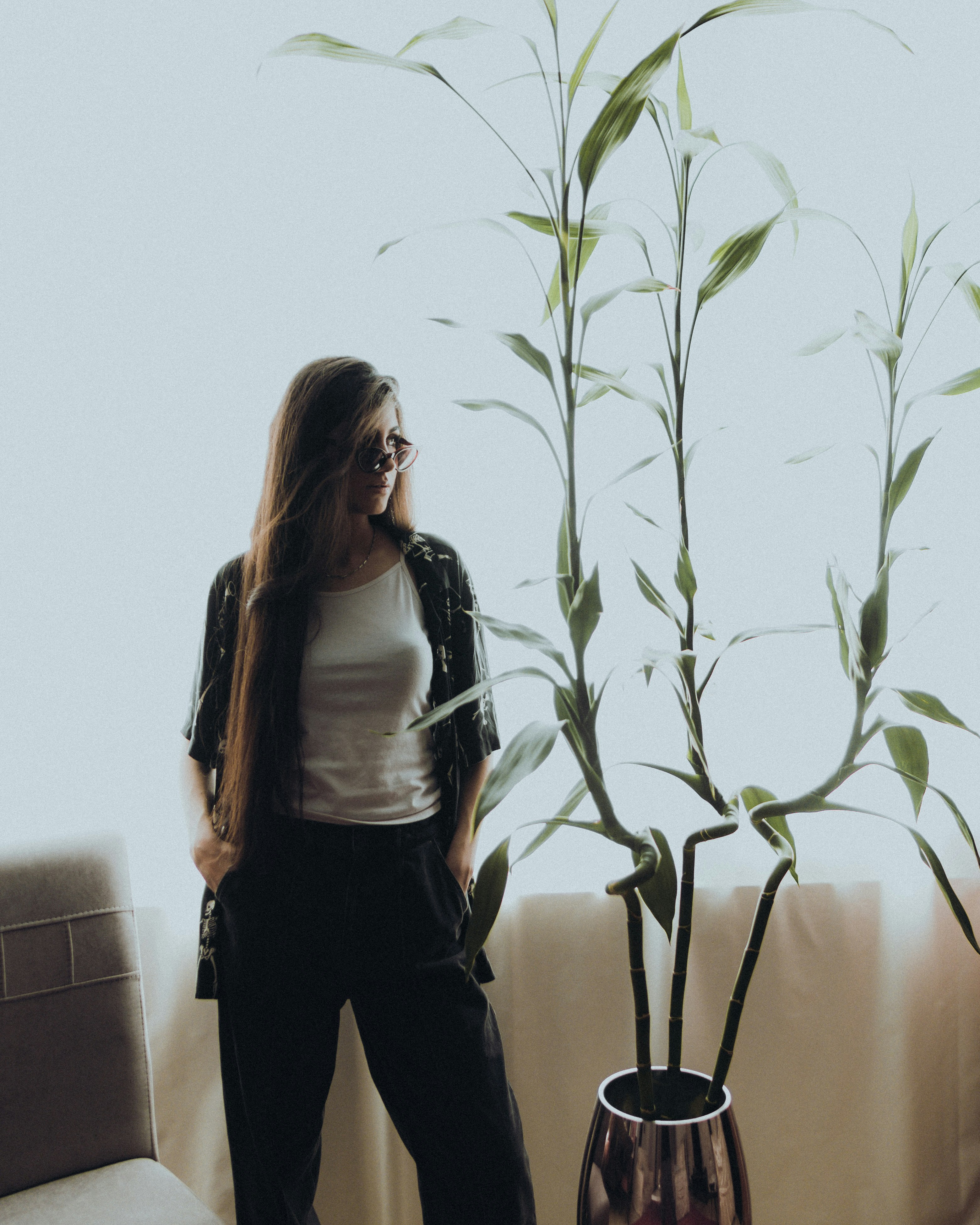 방에 있는 식물 옆에 서 있는 여자
