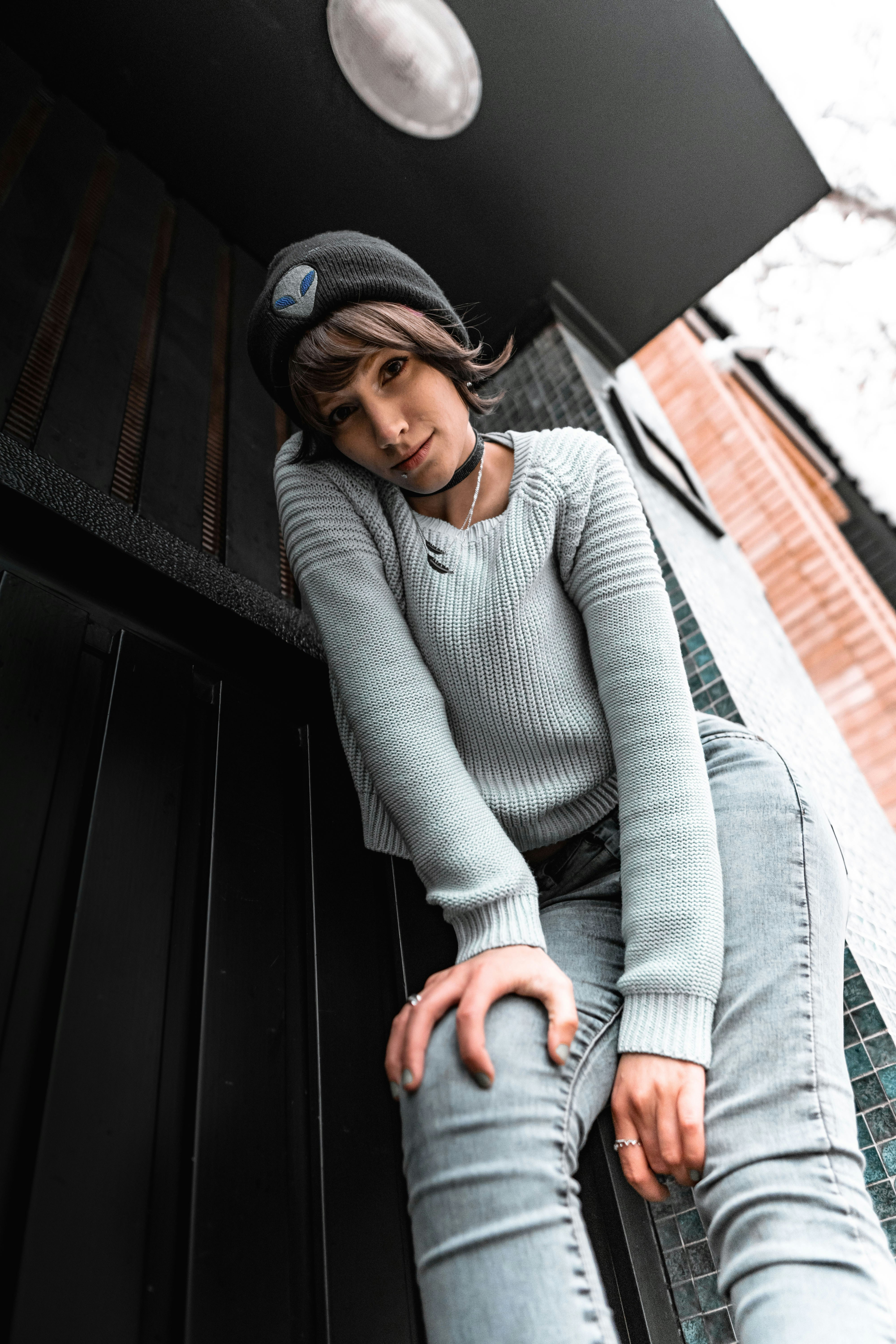 모자를 쓰고 벤치에 앉아 있는 여자