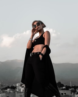 A stylish traveler wearing bindaas clothing, standing confidently on a scenic mountain overlook at sunrise.