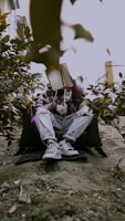 a man sitting on the ground with a book on his head