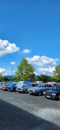 A selection of well-maintained used cars parked in a lot under clear skies.