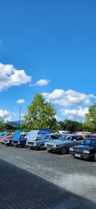 A selection of well-maintained used cars parked in a lot under clear skies.