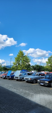 A row of various cars displayed outdoors under clear skies.