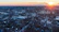 Dynamic drone footage showing sweeping aerial views over a vibrant cityscape at sunset.