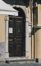 Professional installer mounting a steel door at a residential building entrance.