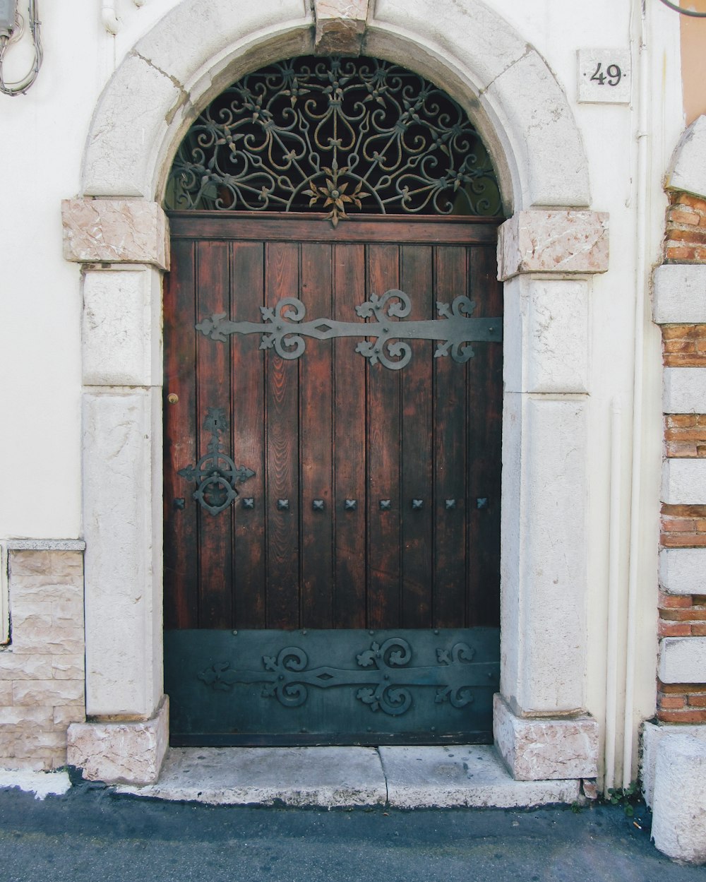 una porta di legno con cancello in ferro battuto