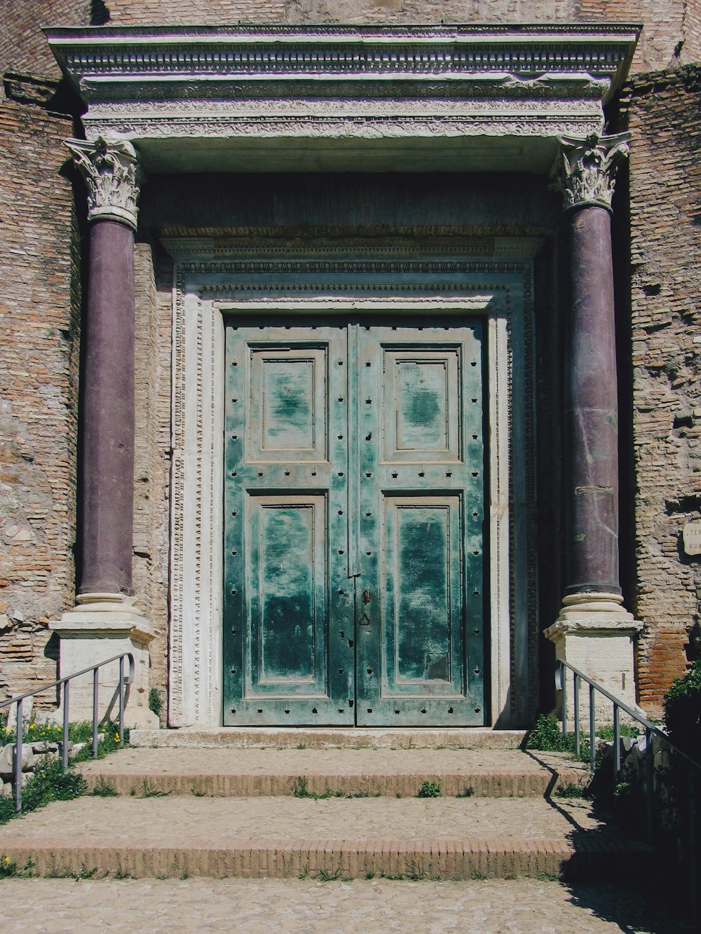 a large wooden door sitting next to a set of steps