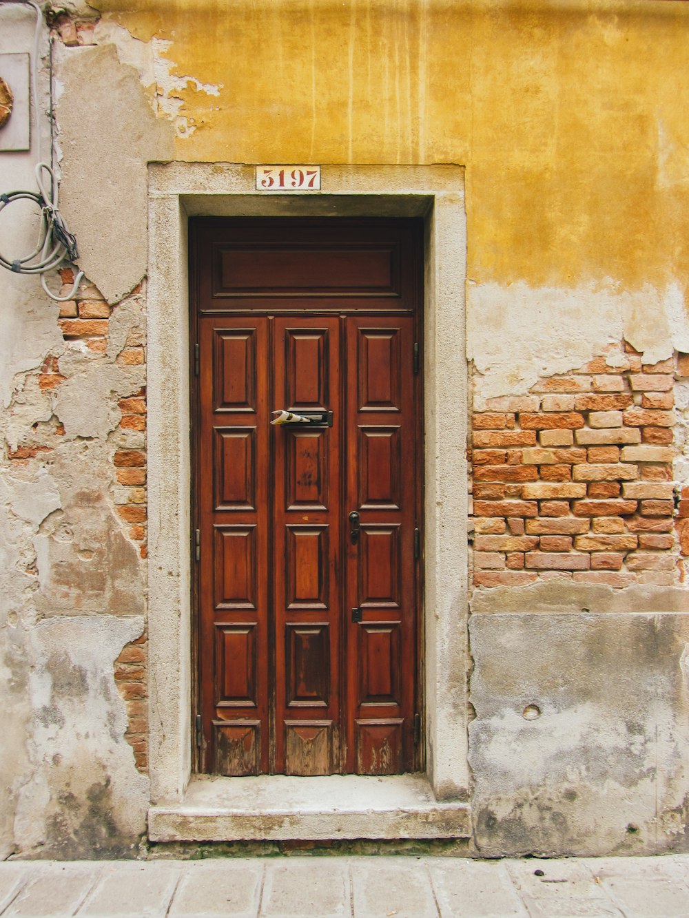 a wooden door in an old building with a brick wall