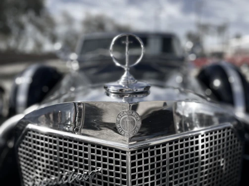 Close-up of a polished chrome grille and emblem on a restored 1960s luxury sedan.
