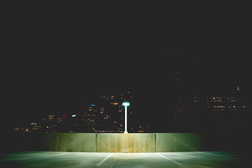 Bright site lighting illuminating a commercial parking lot at dusk.