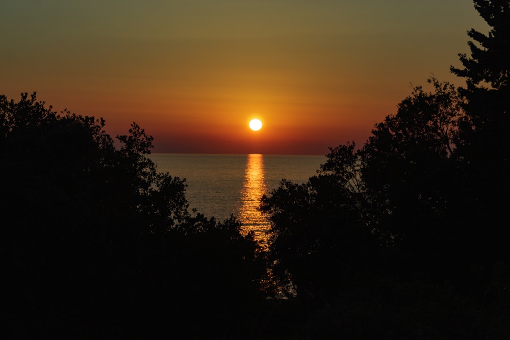 the sun is setting over a body of water