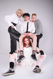 Stylish group photo of diverse artists in a sleek studio with dark mode lighting.