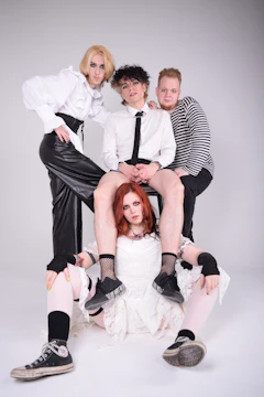 Stylish group photo of diverse artists in a sleek studio with dark mode lighting.