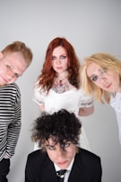 The Beatles posing with their iconic mop-top hairstyles during a photo shoot.