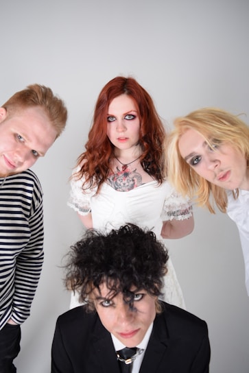 A group of diverse individuals dressed in alternative fashion, showcasing tattoos and unique hairstyles.