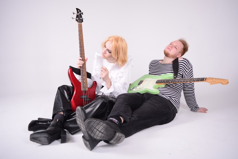 a couple of women sitting next to each other with guitars