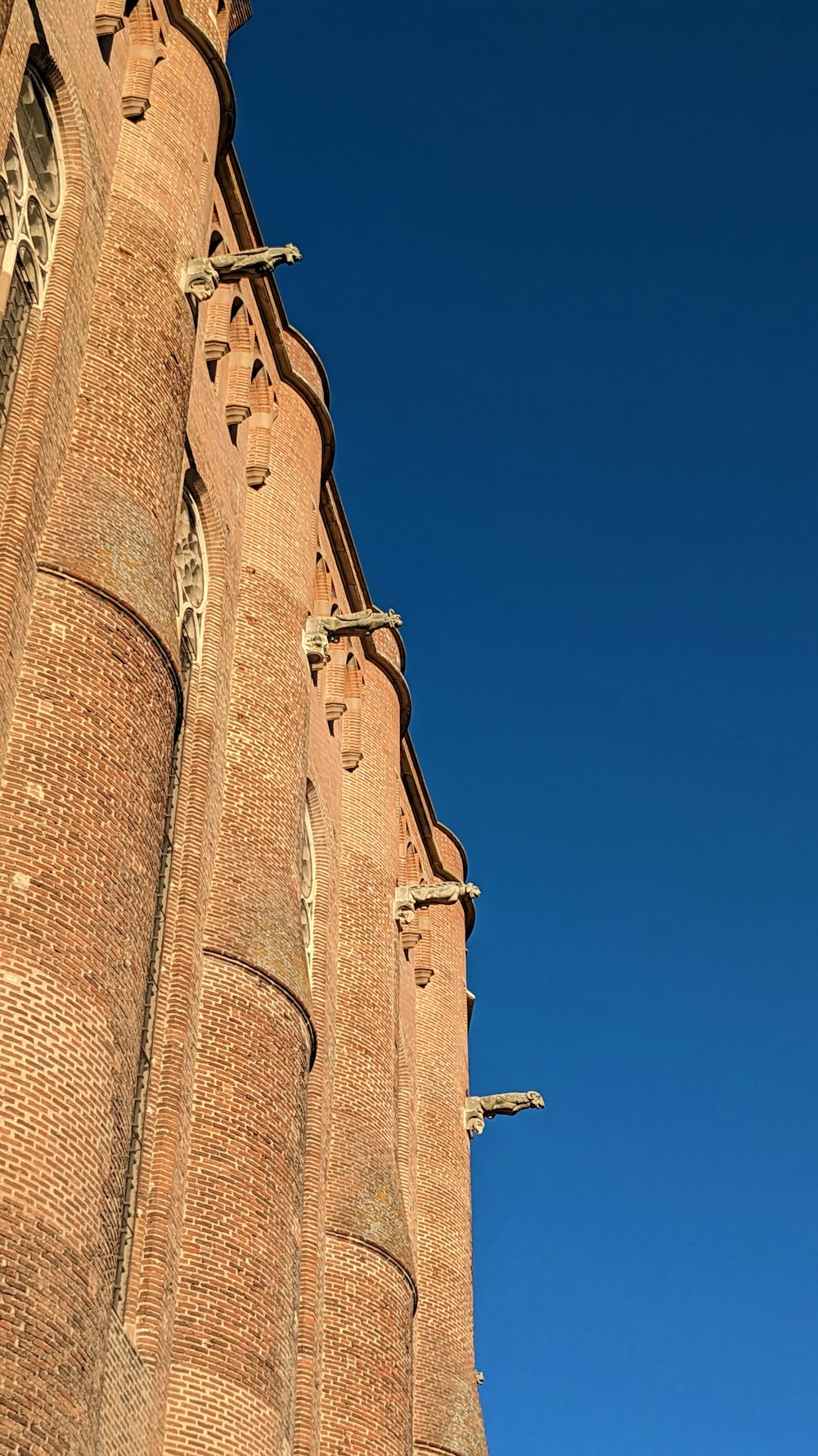 a very tall brick building with a clock on it's side