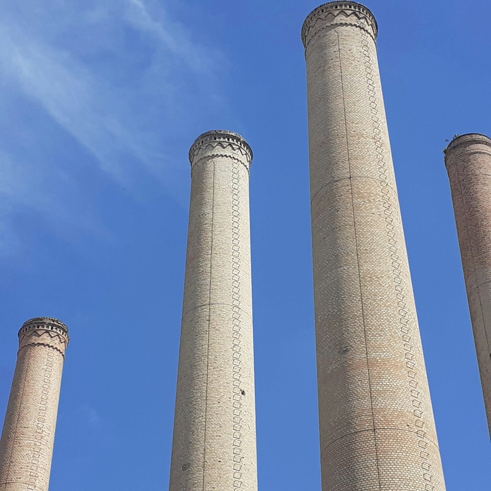 a group of three stone pillars with a blue sky in the background