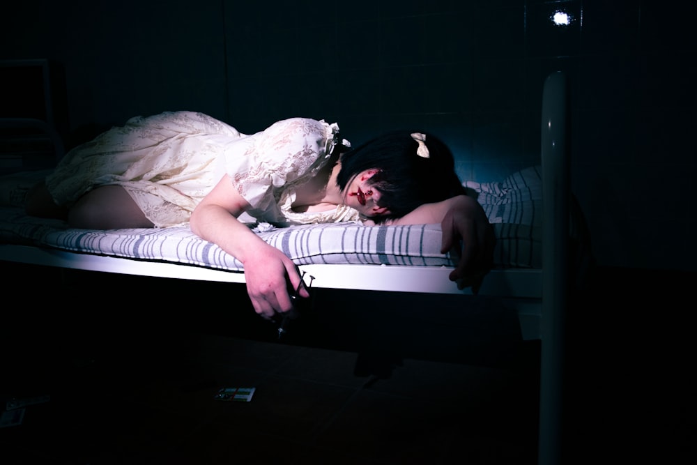 a woman laying on a bed in a dark room